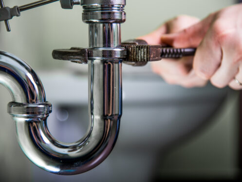 A plumber working on the bathroom sink drain.